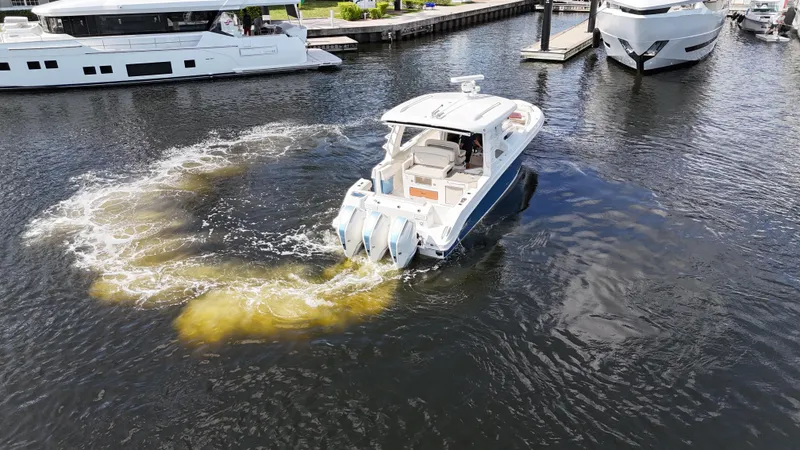 Slide: The Image of 2020 Boston Whaler 350 Realm maneuvering in marina, creating circular water pattern. - 17