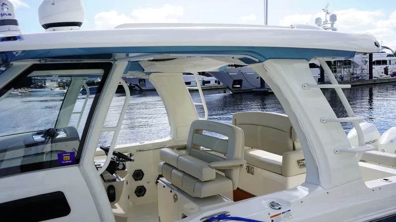 Slide: The Image of 2020 Boston Whaler 350 Realm boat interior with seating and helm, docked at marina. - 26