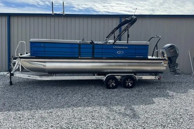The Image of 2026 Veranda VV22RC pontoon boat on trailer, parked on gravel near a metal building. - 1