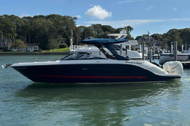The Image of 2017 Sea Ray SLX 310 Outboard boat docked in a scenic marina setting. - 0