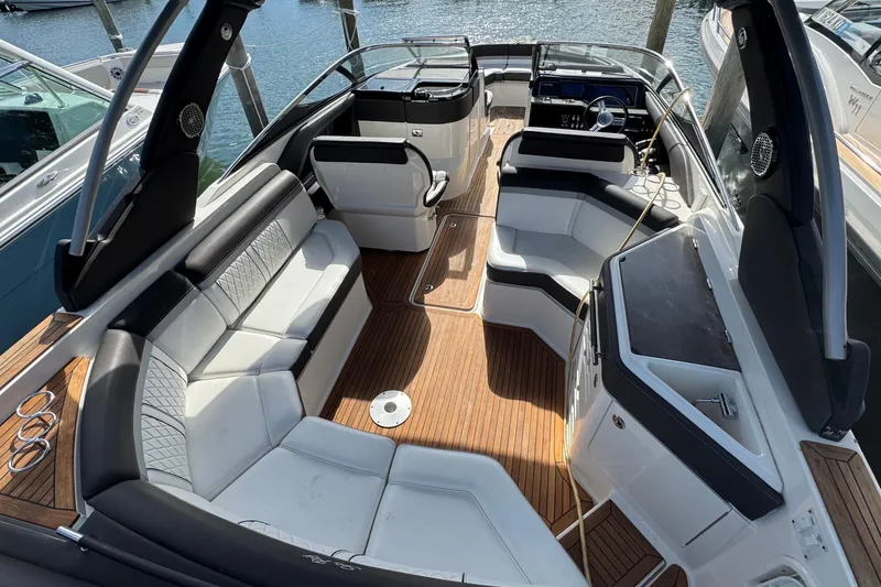 Slide: The Image of 2017 Sea Ray SLX 310 Outboard boat interior with luxurious seating and wood flooring. - 12