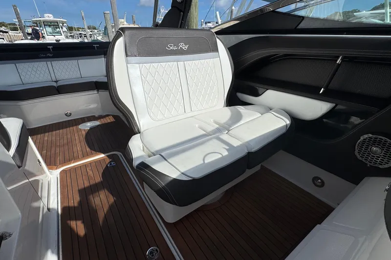 Slide: The Image of 2017 Sea Ray SLX 310 Outboard interior with luxurious seating and wood flooring. - 17