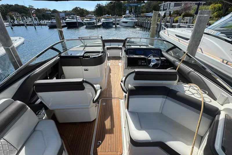 Slide: The Image of 2017 Sea Ray SLX 310 Outboard boat interior with luxurious seating and wooden flooring. - 18