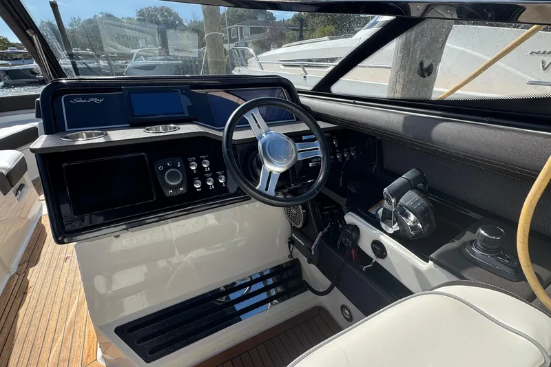 Slide: The Image of 2017 Sea Ray SLX 310 Outboard helm with steering wheel and controls. - 21