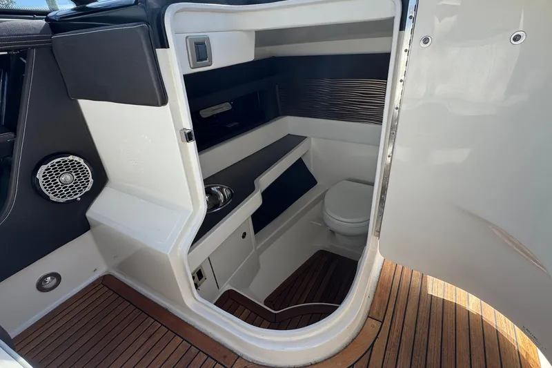 Slide: The Image of 2017 Sea Ray SLX 310 Outboard interior cabin with toilet and wooden flooring. - 25