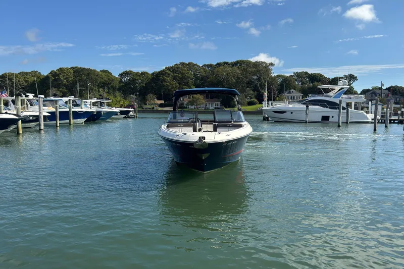 Slide: The Image of 2017 Sea Ray SLX 310 Outboard boat on calm water near a marina. - 3