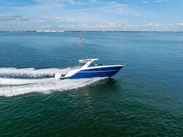 Slide: The Image of 2017 Sea Ray SLX 310 Outboard boat interior with sink, toilet, and wooden flooring. - 34