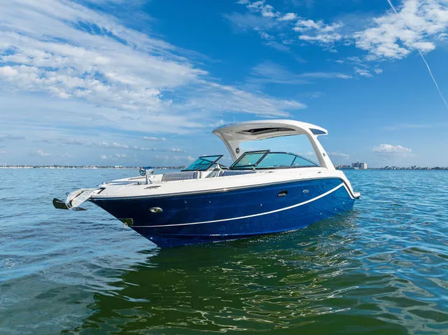 Slide: The Image of 2017 Sea Ray SLX 310 Outboard boat docked near wooden building, showcasing sleek design. - 43