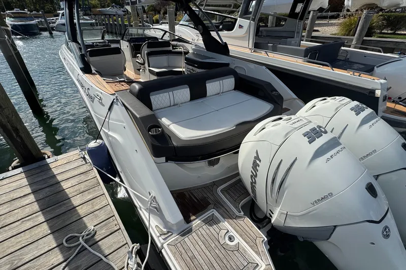 Slide: The Image of 2017 Sea Ray SLX 310 Outboard boat docked, featuring twin Mercury engines. - 8