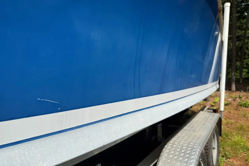 Slide: The Image of 1965 Bertram boat with blue hull on a trailer, side view. - 12