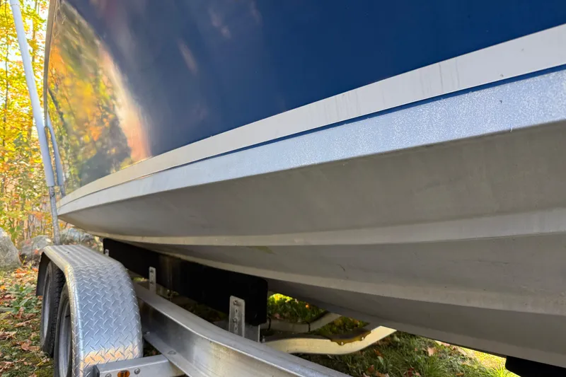 Slide: The Image of 1965 Bertram boat on trailer, blue hull, outdoors in sunlight. - 17