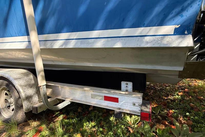 Slide: The Image of 1965 Bertram boat on trailer, blue hull, parked on grass with autumn leaves. - 20