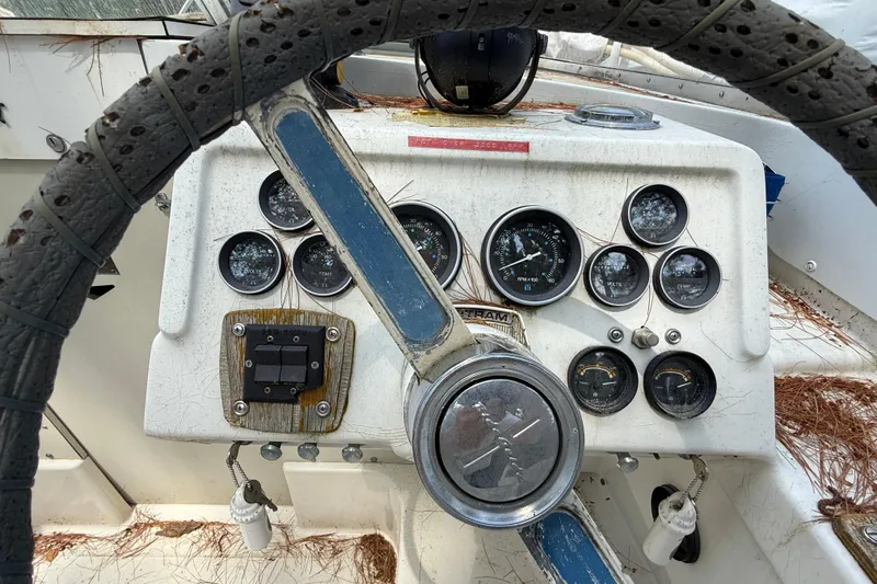 Slide: The Image of 1965 Bertram boat dashboard with vintage gauges and steering wheel. - 23