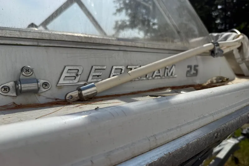 Slide: The Image of Close-up of a 1965 Bertram 25 boat with visible logo and hardware. - 25