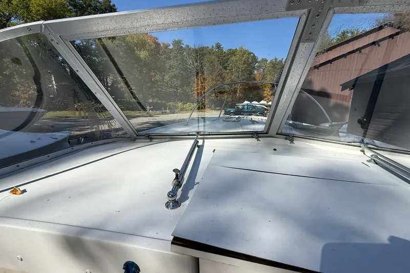 Slide: The Image of 1965 Bertram boat windshield view with trees and building in the background. - 28