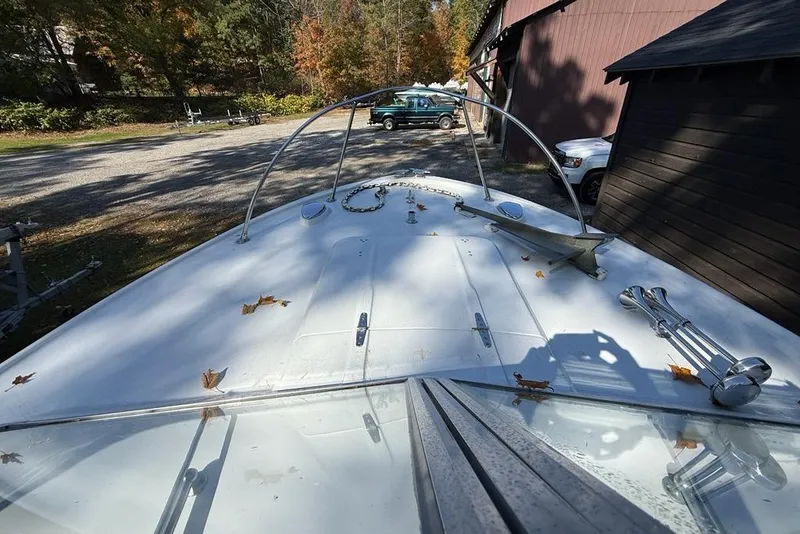 Slide: The Image of 1965 Bertram boat deck with autumn leaves, parked near a wooden building. - 29