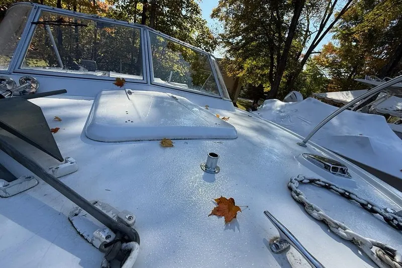 Slide: The Image of 1965 Bertram boat deck with autumn leaves, anchor, and chain under trees. - 33