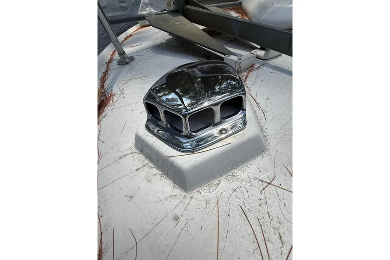 Slide: The Image of Chrome vent on 1965 Bertram boat deck, surrounded by pine needles. - 34