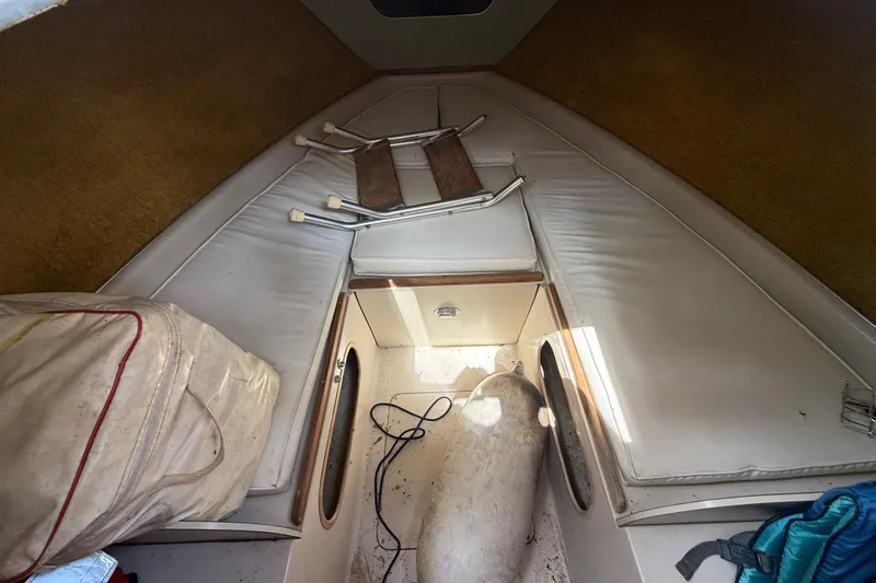 Slide: The Image of Interior of a 1965 Bertram boat with white cushions and storage space. - 39
