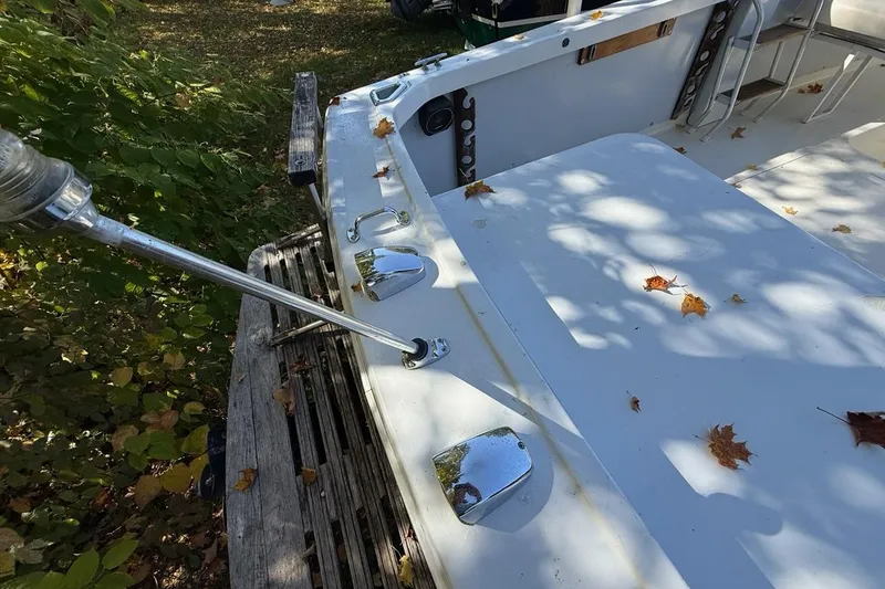 Slide: The Image of 1965 Bertram boat deck with chrome fixtures and autumn leaves scattered. - 42