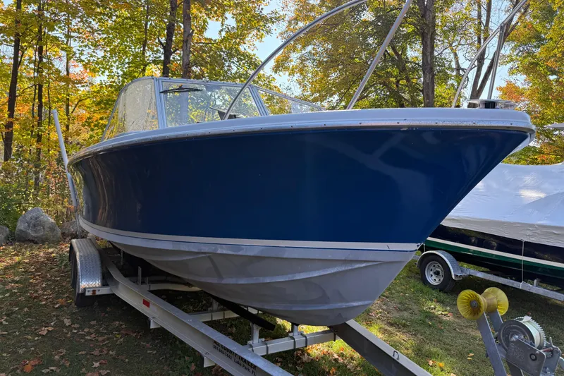 Slide: The Image of 1965 Bertram boat on trailer, surrounded by autumn trees. - 5