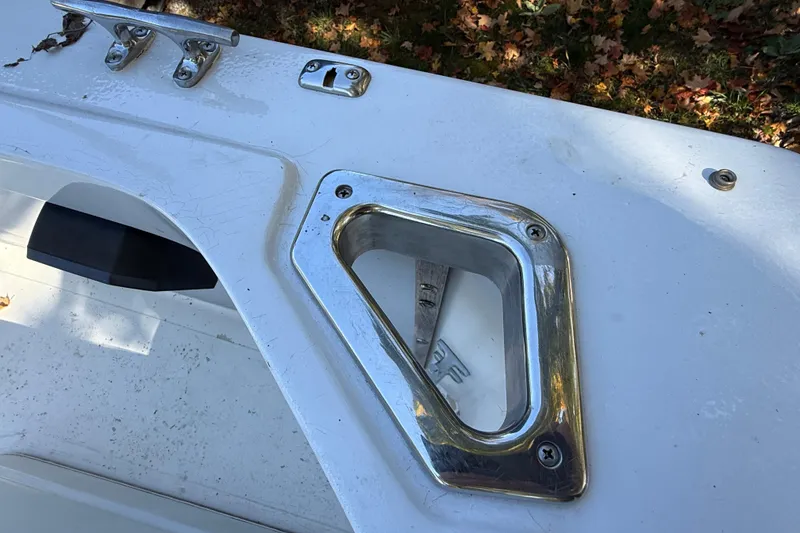 Slide: The Image of 1965 Bertram boat deck with chrome fittings and cleat, surrounded by autumn leaves. - 51