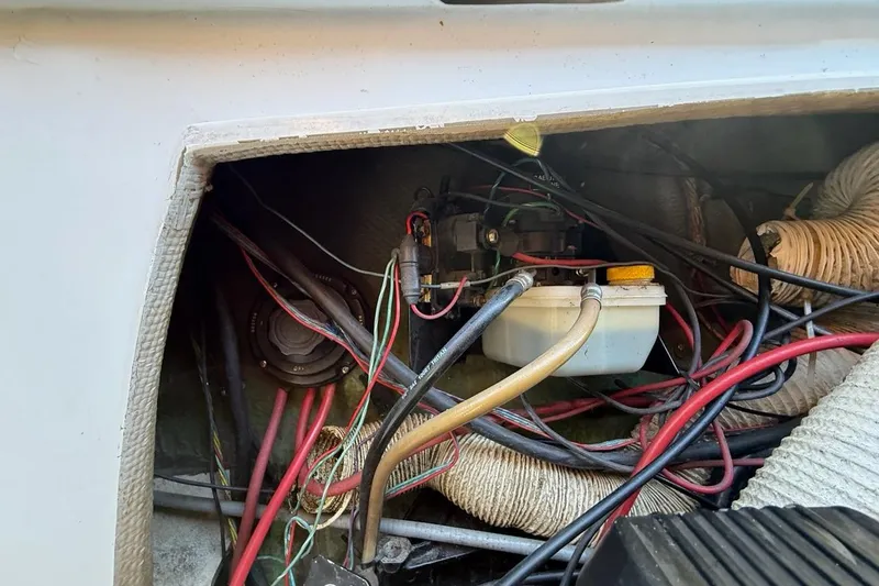 Slide: The Image of 1965 Bertram boat wiring and components in a compartment, showcasing cables and connections. - 52