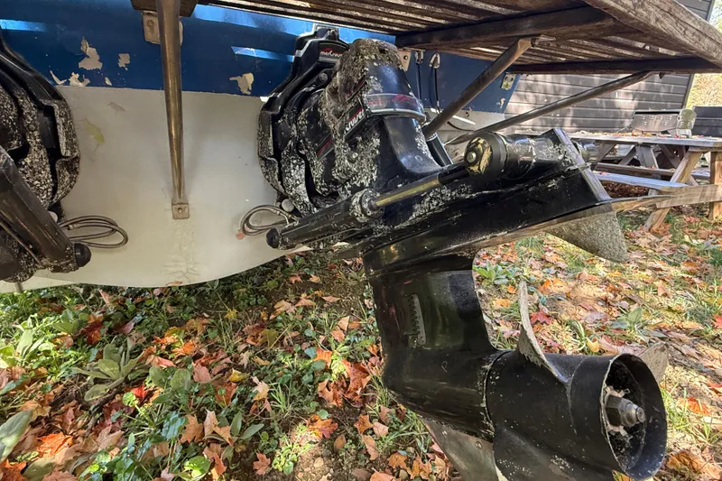 Slide: The Image of 1965 Bertram boat stern with dual outboard motors, surrounded by autumn leaves. - 62