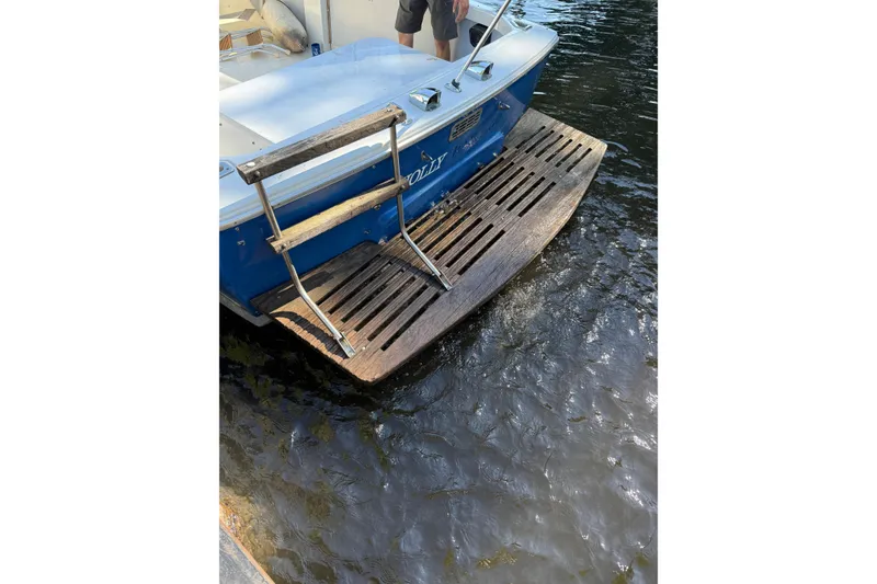 Slide: The Image of 1965 Bertram boat with wooden swim platform and ladder on water. - 65