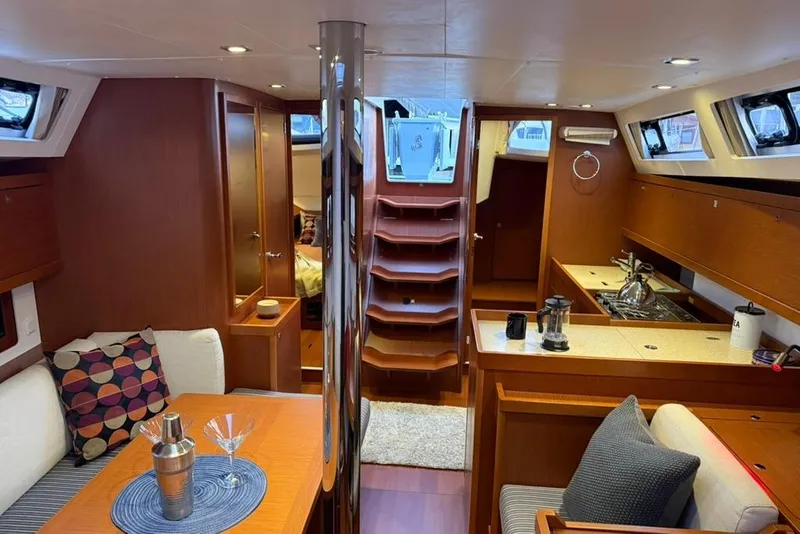 Slide: The Image of Interior of 2014 Beneteau Oceanis 41 sailboat, featuring cozy seating and modern kitchen amenities. - 2