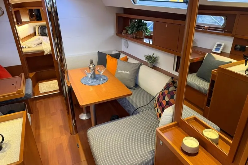 Slide: The Image of Interior of 2014 Beneteau Oceanis 41 yacht, featuring cozy seating and elegant wooden finishes. - 4