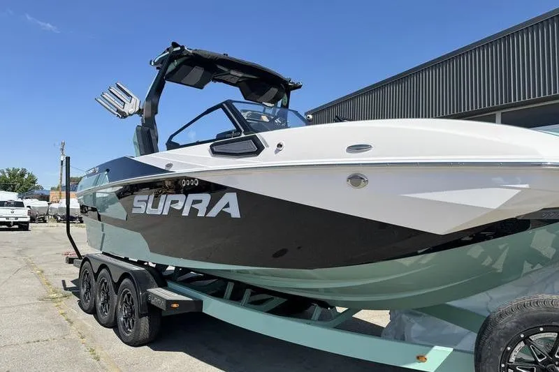 Slide: The Image of 2024 Supra SE 575 boat on trailer, sleek design, parked outdoors. - 4