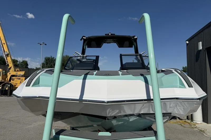 Slide: The Image of 2024 Supra SE 575 boat in a parking area under clear blue sky. - 5