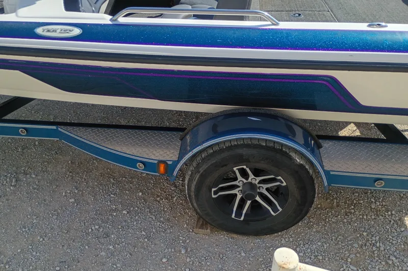 Slide: The Image of 2003 Skeeter TZX190 boat on trailer, featuring blue and purple accents. - 4