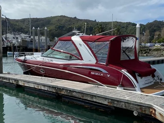 Slide: The Image of 2012 Formula 350 Sun Sport boat docked at marina with scenic hillside background. - 4