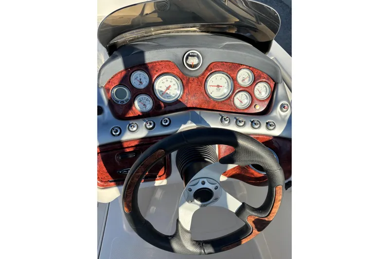 Slide: The Image of Steering wheel and dashboard of 2014 Tahoe 215 Xi boat with gauges and controls. - 13
