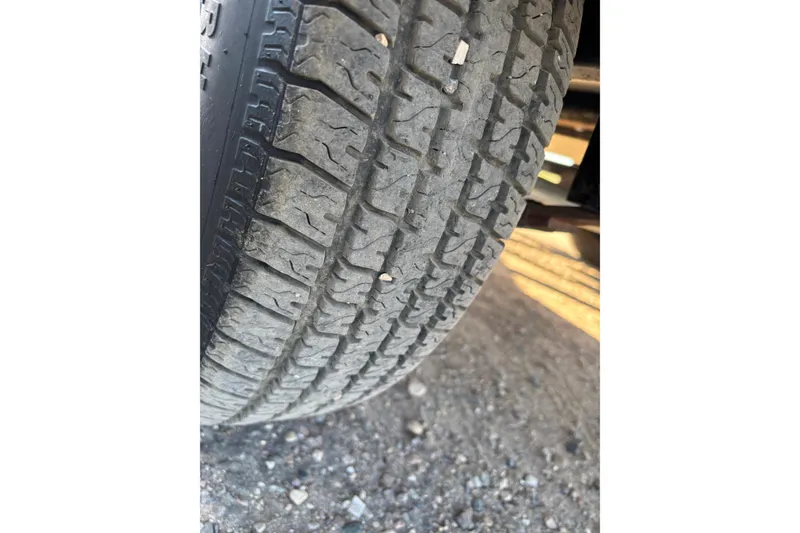 Slide: The Image of Close-up of a 2014 Tahoe 215 Xi tire with visible tread pattern. - 20