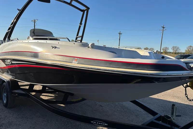 Slide: The Image of 2014 Tahoe 215 Xi boat on trailer, sleek design with red and black accents. - 3