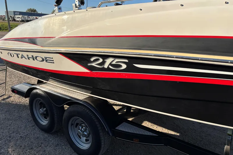 Slide: The Image of 2014 Tahoe 215 Xi boat on trailer, featuring red and black accents. - 4