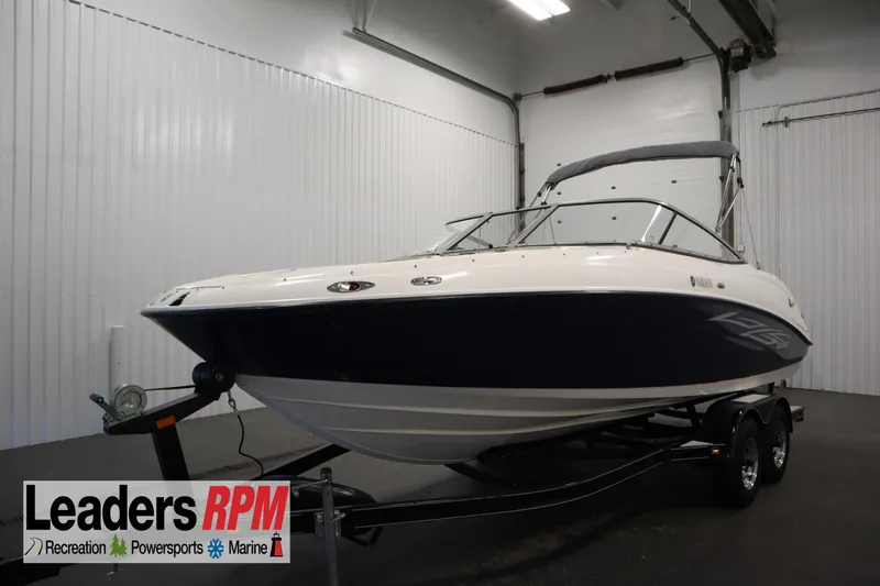 The Image of 2010 Yamaha 210 SX boat on trailer in indoor showroom. - 1