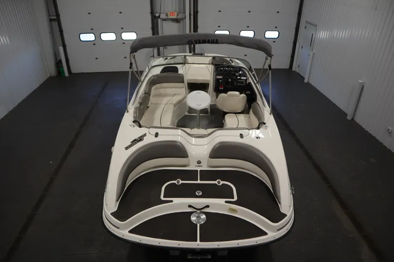 Slide: The Image of 2010 Yamaha 210 SX boat in indoor storage, featuring spacious seating and sleek design. - 10