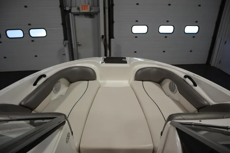 Slide: The Image of 2010 Yamaha 210 SX boat interior with cushioned seating in a garage setting. - 11