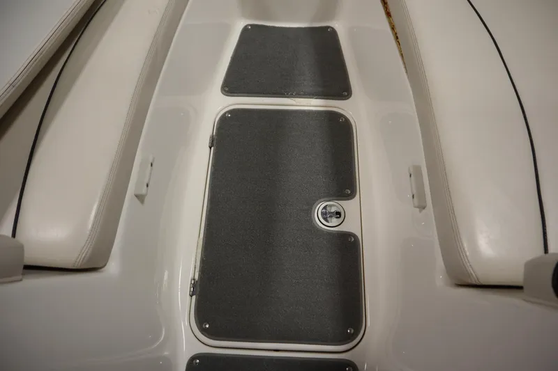 Slide: The Image of 2010 Yamaha 210 SX boat interior with gray carpeted storage compartments. - 16