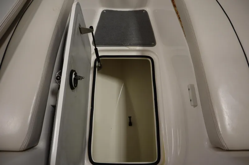 Slide: The Image of Open storage compartment on a 2010 Yamaha 210 SX boat, featuring a secure latch. - 17