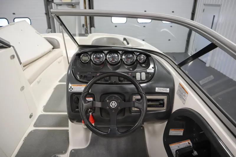 Slide: The Image of 2010 Yamaha 210 SX boat dashboard with steering wheel and gauges in a garage setting. - 19