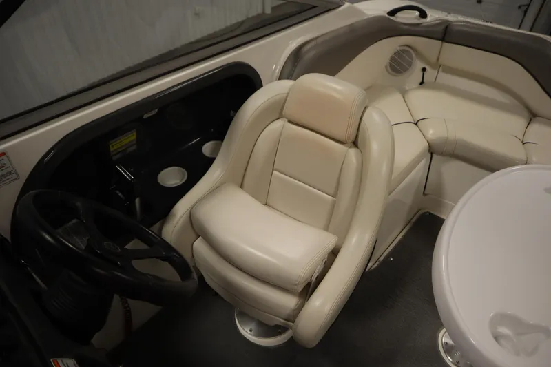 Slide: The Image of Interior of a 2010 Yamaha 210 SX boat featuring beige seating and steering wheel. - 29