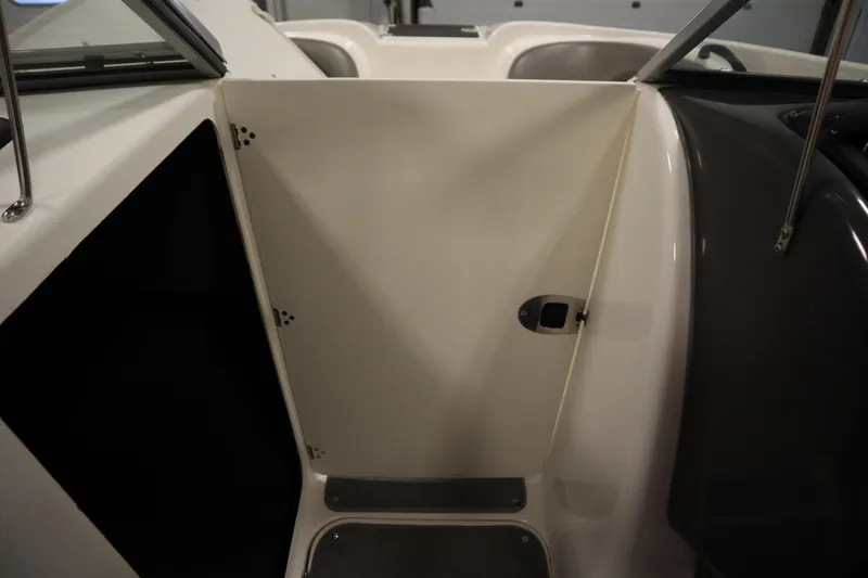 Slide: The Image of Interior view of a 2010 Yamaha 210 SX boat, featuring a closed cabin door. - 33