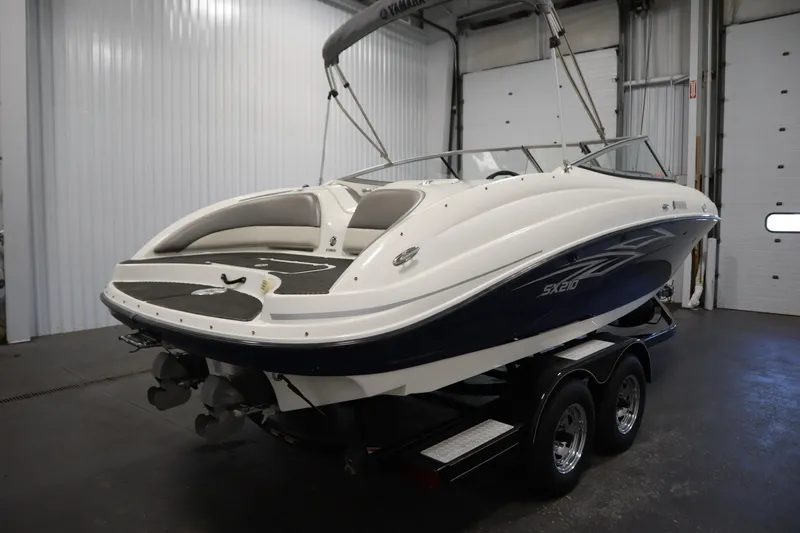 Slide: The Image of 2010 Yamaha 210 SX boat in a garage, on a trailer, with sleek design. - 5
