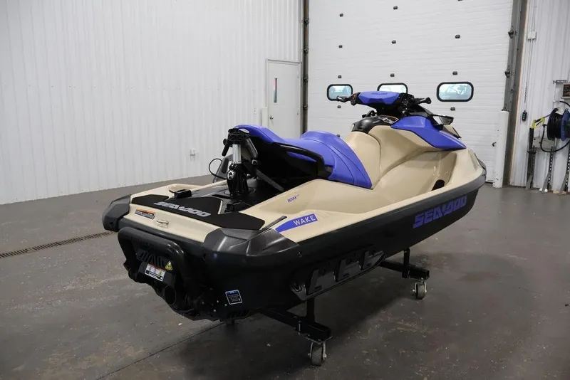 Slide: The Image of 2026 Sea-Doo Wake 170 jet ski in a garage, featuring a beige and blue design. - 1