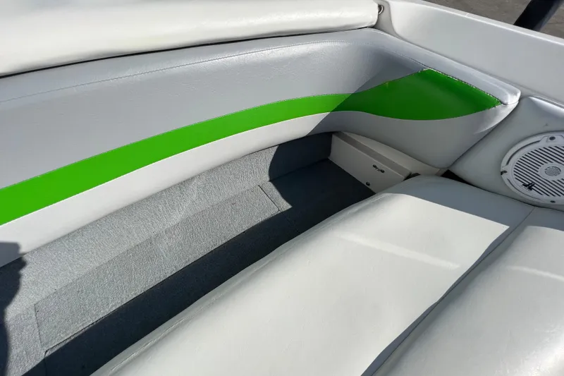 Slide: The Image of 2003 MasterCraft XStar boat interior with green and gray upholstery, featuring a speaker. - 21